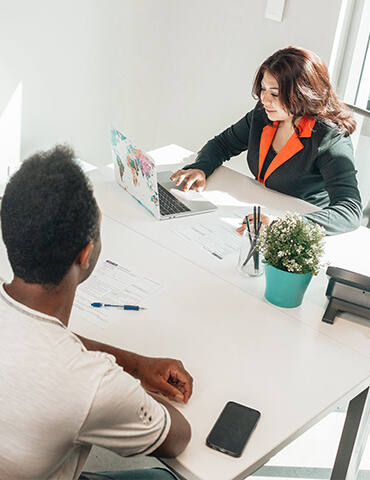 Two people engaged in a professional discussion at a desk.