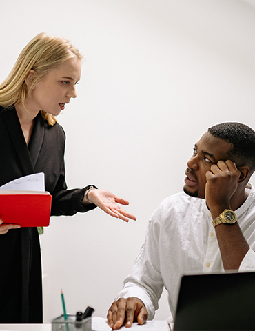 A woman explaining something to a man who looks confused.