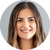 Smiling young woman with long hair against a neutral background.